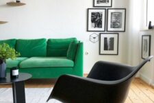 a Scandinavian living room with an emerald sofa, a black Eames rocker, a black coffee table and a gallery wall