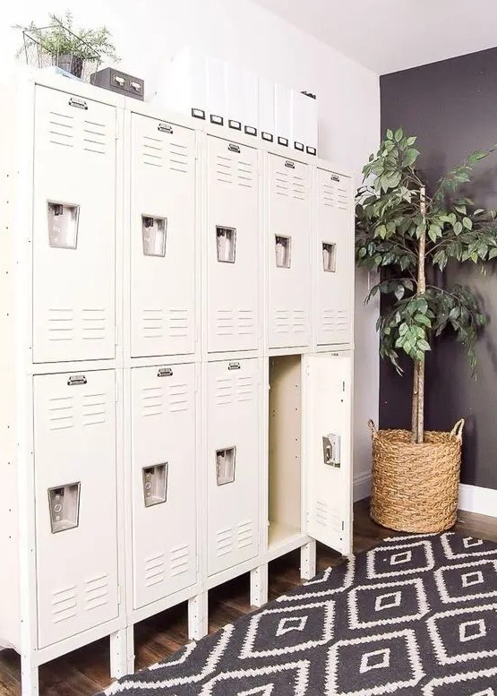 a Scandinavian space with white lockers, a printed rug, potted greenery is a lovely space to be in, it looks very stylish