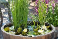 a barrel water garden with water lilies and greenery for a slight romantic and rustic touch to the space