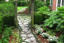 a beautiful and delicate stone garden path with moss and greenery between the stones feels like a secret garden path
