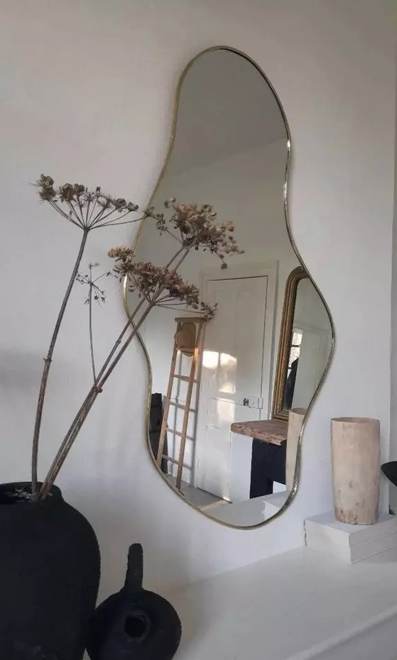 a beautiful organic-shaped mirror in a super delicate brass frame is a lovely solution for a Scandinavian space
