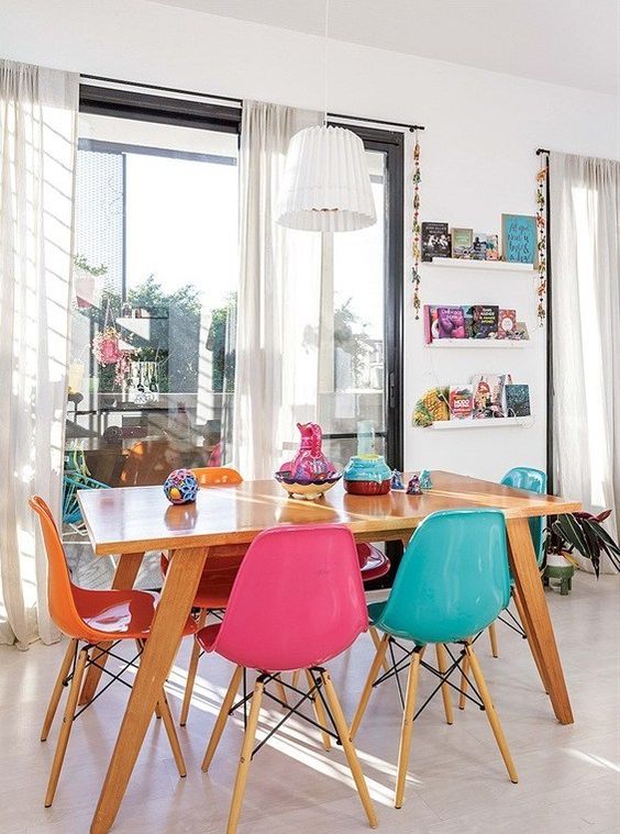 a bold dining space with open shelves, a stained table, bold Eames chairs and colorful vases is a stylish and cool area