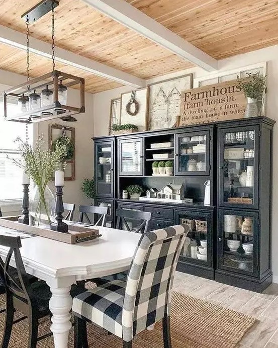a chic modern farmhouse dining space with black storage units, a white vintage table and mismatching chairs plus a jar chandelier