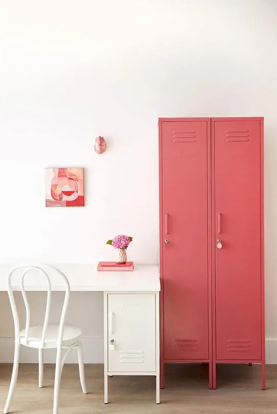 a cool home office with a creamy desk and a locker for storage, coral lockers for storage and some pink and coral art