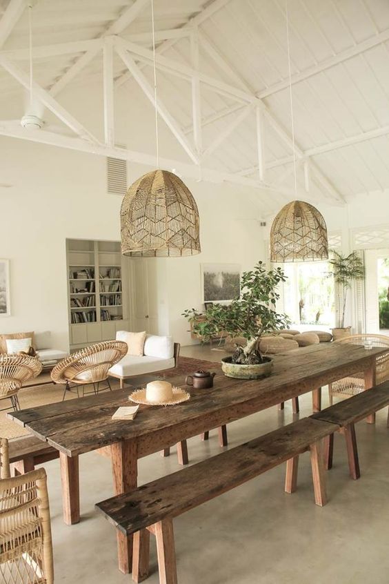a cool rustic dining zone with a large stained dining table and benches, woven pendant lamps and a potted mini tree