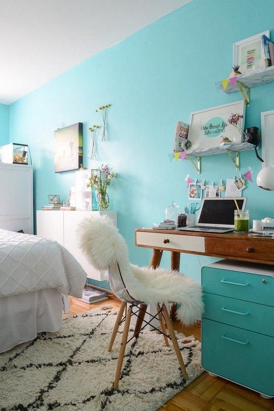 a cool teen bedroom with a bed and white furniture, a mid century modern desk and a white chair, some shelves