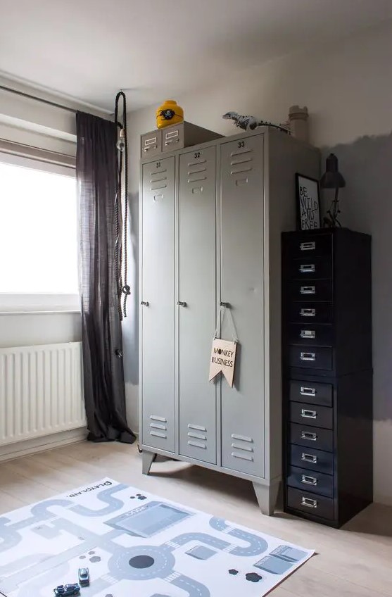 a kid's space finished off with grey lockers, with black flie cabinets that provide a lot of storage space