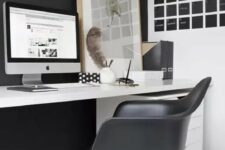 a modern home office with a black accent wall