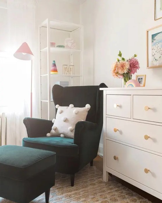 a little nook in the kid's room with a dark green Strandmon chair and a matching ottoman, a dresser and a shelving unit in the corner