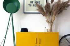 a mid-century modern entryway with a mustard locker, pampas grass, a green floor lamp and a metal basket for storage