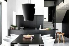 a minimalist black and white dining space with a black table, a black and white chairs, black pendant lamps and a black bar counter is very edgy and bold
