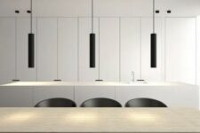 a minimalist dining space with a stained table, black chairs, black tube pendant lamp and white storage units
