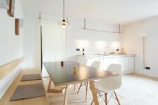 a minimalist meets Scandinavian dining space with a wall-mounted bench, a comfy table, white Eames chairs, box shelves on the wall