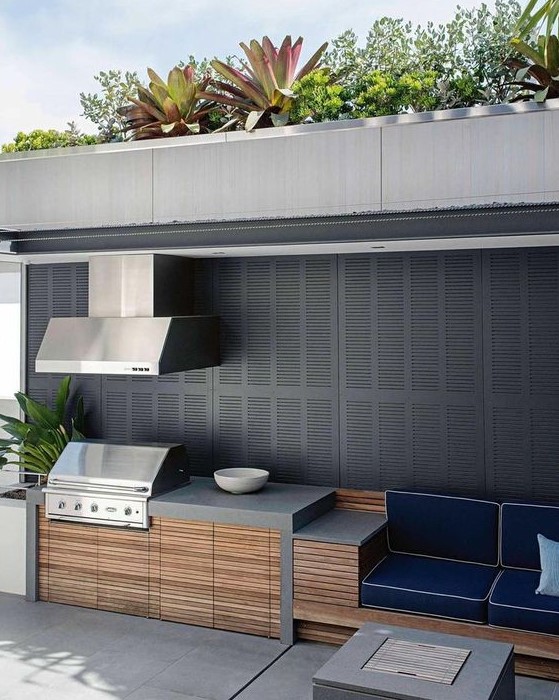 a minimalist outdoor bbq area of concrete, wood and metal with a cooking zone, a grill with a hood and a sitting zone