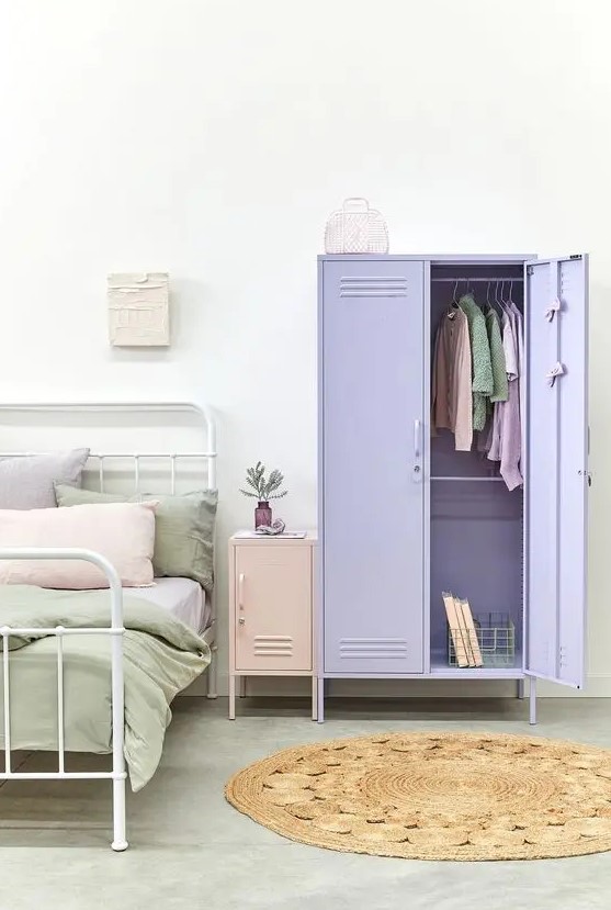 a pastel bedroom with a white metal bed, pastel bedding, a blush locker nightstand and a lilac locker as a wardrobe is a lovely space