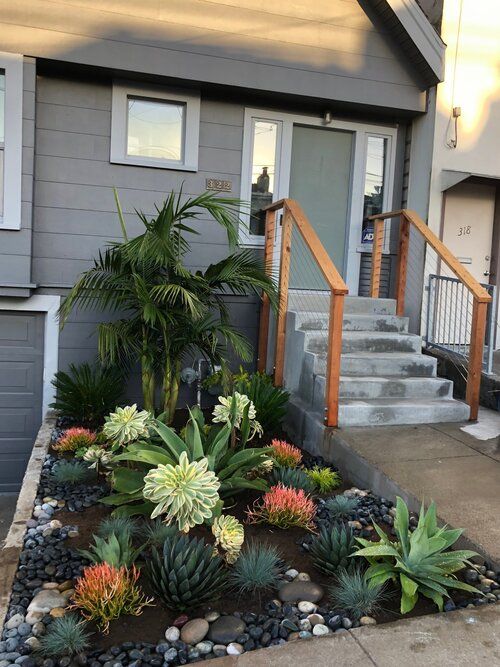 a pretty mini succulent garden in bright and dark green, with bold orange blooms and some tropical plants is a cool and catchy idea