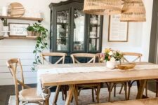 a rustic dining space with a black storage unit, a stained wooden table and a bench, lovely stained chairs and a cluster of pendant lamps
