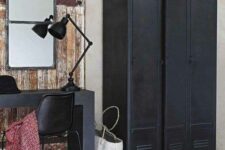 a shabby chic meets industrial space with black lockers, a black desk and chair, a black lamp and a mirror is a cool and lovely space