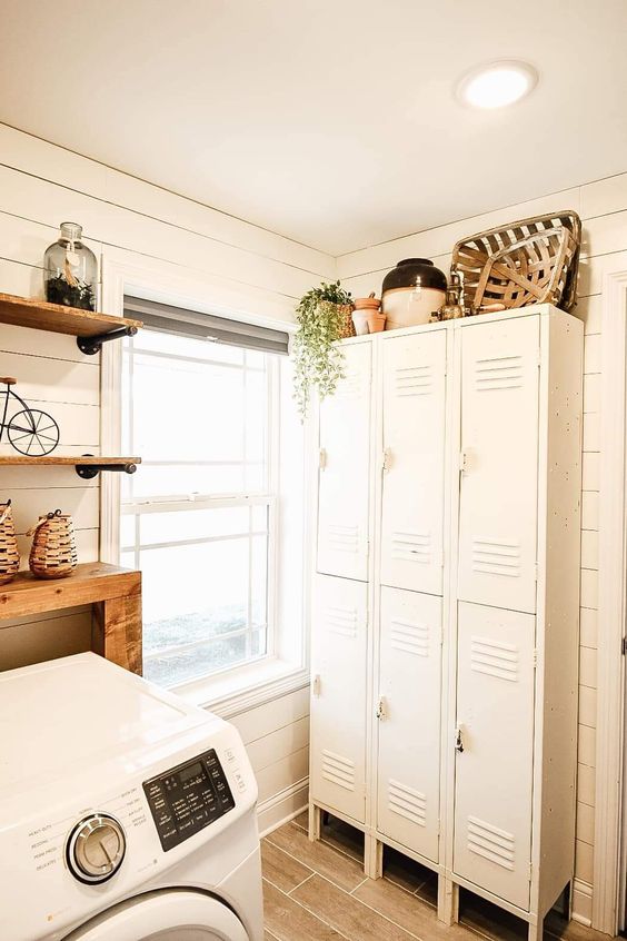 a small neutral laundry with shiplap walls, a stack of white lockers, stained shelves and baskets is a cool space