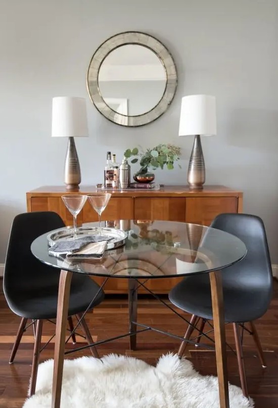 a small round table with wooden and metal legs and a glass tabletop for a cozy dining space or breakfast nook