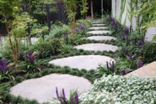 a stone garden path with large rocks, greenery and grasses in between, is a cool and bold solution for a modern space