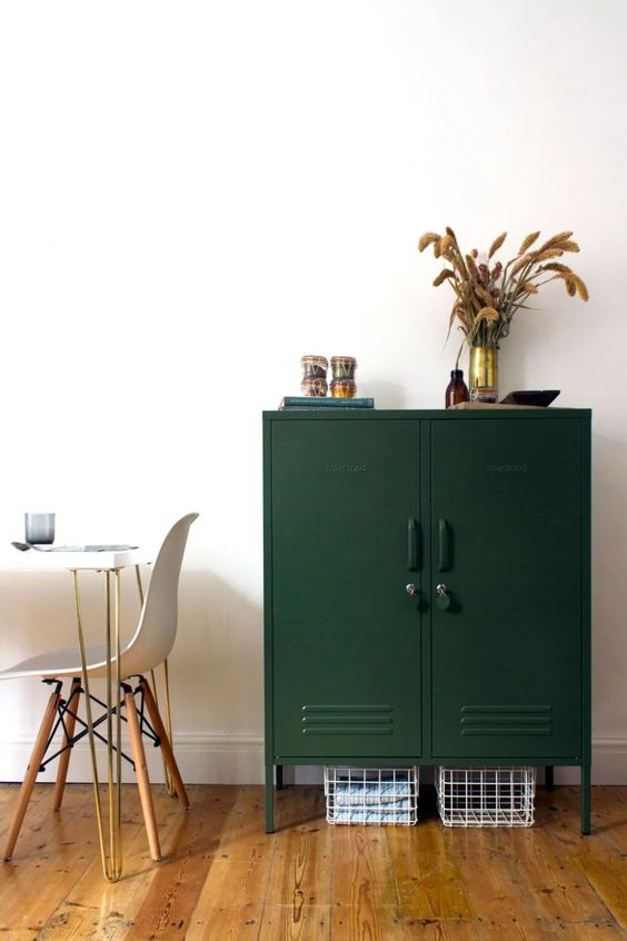 a stylish dark green locker with metal baskets underneath is a cool and catchy idea for a modern space, it provides a lot of storage