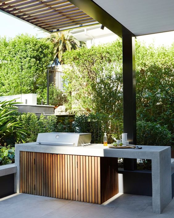a stylish minimalist outdoor barbecue area with a concrete countertop and a fluted cabinet, a grill is a perfect space