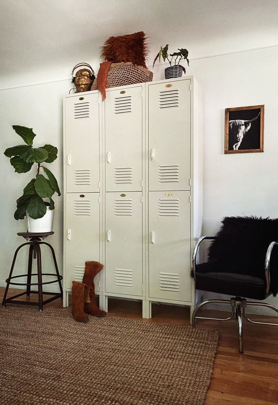 a stylish space with a black faux fur chair, a set of white lockers, a statement plant and some creative decor