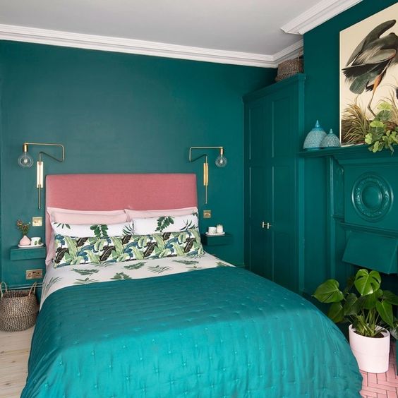 a super bold modern bedroom done in turquoise to emerald, with a pink bed and turquoise bedding and potted plants