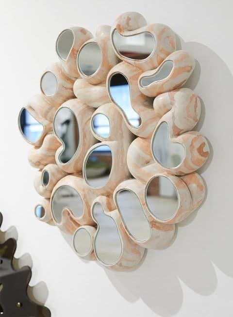 a unique mirror of seashells topped with matching mirror pieces seems an out of this world creature or decoration