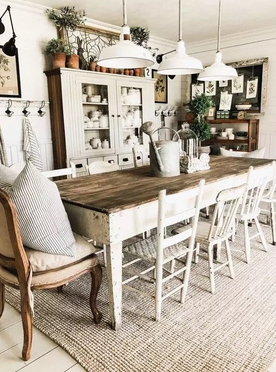 a welcoming farmhouse dining area with whitewashed furniture, upholstered chairs, white pendant lamps and a neutral buffet