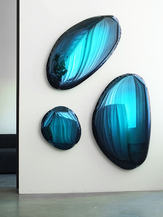 an arrangement of blue irregular-shaped mirrors is a cool decoration for any modern space, it will make a statement just like a gallery wall