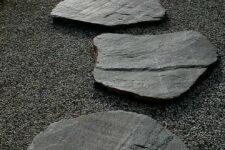 grey gravel and large rough stones for a path make up a cool and bold pathway with a zen feel