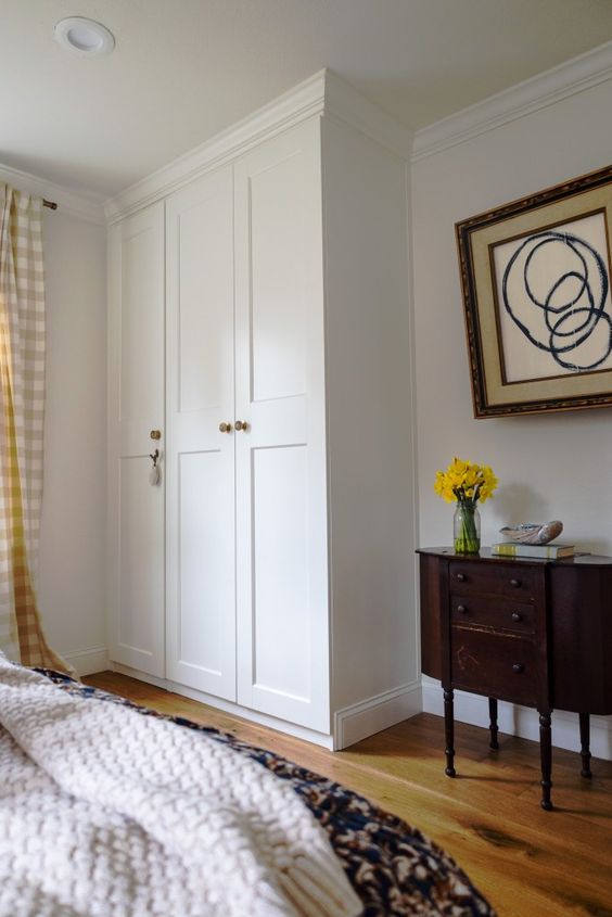 a beautiful built in IKEA Pax wardrobe with gold knobs is a cool and stylish idea for a bedroom, it looks nice and lovely