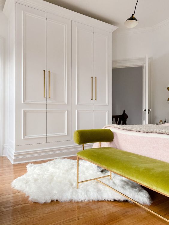 a chic bedroom featuring a white wardrobe made of two IKEA Pax pieces with gold handles looks very chic and cool