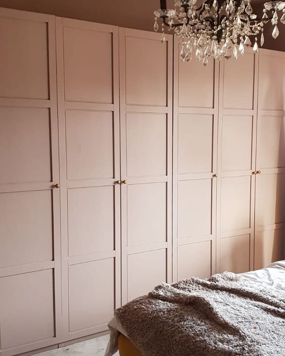 a glam bedroom with blush IKEA Pax wardrobes and gold knobs, a crystal chandelier is a gorgeous and chic idea
