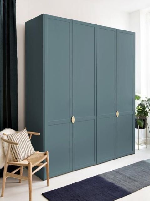 a stylish IKEA Pax hack with slate blue paint and new doors plus elegant gold knobs is a very cool idea for a modern space