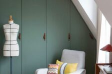 34 an attic bedroom with built-in green IKEA Pax wardrobes with leather handles, a neutral chair with bold pillows