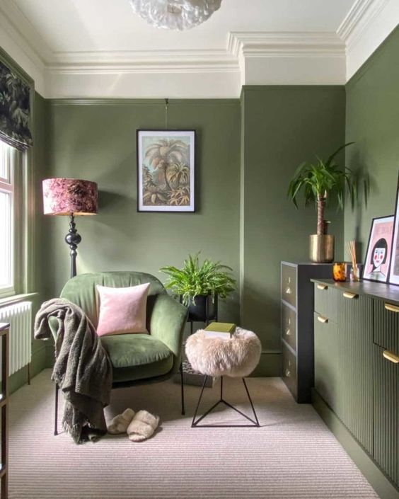 an olive green space with matching furniture, some light pink accents, potted plants and bold artwork is amazing