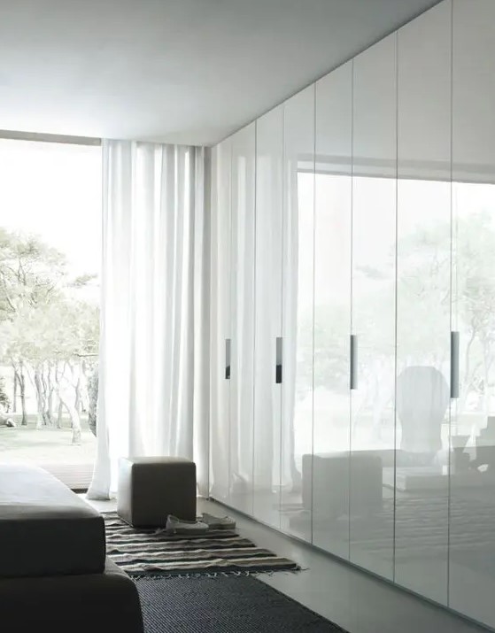 sleek white doors with handles look shiny and reflect natural light making the space look larger