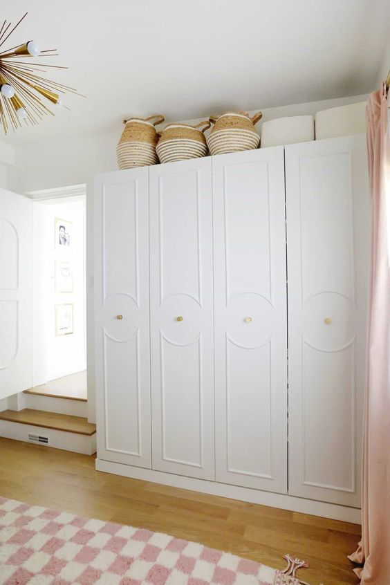 white IKEA Pax wardrobes customized with trim and with gold knobs are adorable for a Scandinavian space