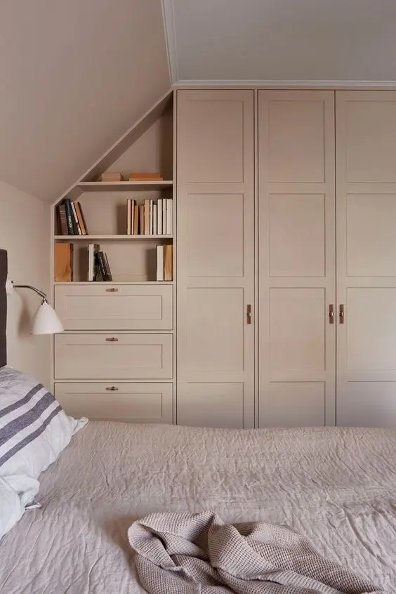 a lovely blush bedroom with matching blush IKEA Pax wardrobes, open shelves and drawers, a bed with blush bedding