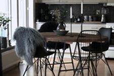 a Nordic dining space with a stained table, black Eames and Eames wire chairs, a black pendant lamp is cool