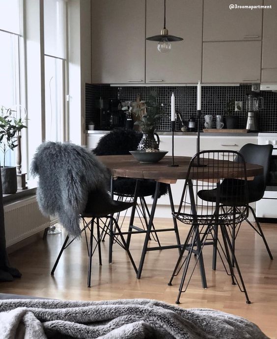 a Nordic dining space with a stained table, black Eames and Eames wire chairs, a black pendant lamp is cool