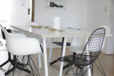 a Scandinavian dining space with a white table, white Eames chairs and black Eames wire chairs, a pendant lamp