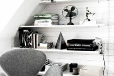 a Scandinavian nook with built-in shelves and black and white decor, a grey Swan chair and a jute rug is lovely