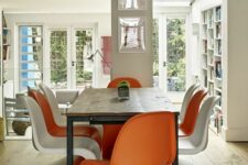 a bold dining room with a stained living edge table, orange and white Panton chairs and some bright artwork