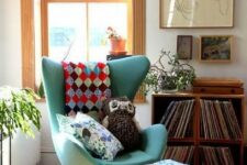 a bright boho nook with crates with vinyl, some artwork, a green Egg chair and a footrest, potted plants is cool