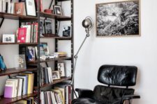 a catchy reading nook with a large industrial bookcase, a black Eames lounger, a bold rug and some industrial lamps