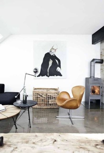 a monochromatic living room with a hearth, a black sofa, a basket with firewood, an amber Swan chair and a couple of coffee tables